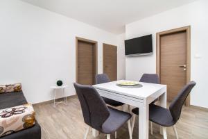 ein Esszimmer mit einem weißen Tisch und Stühlen in der Unterkunft Apartment Split4me in Split