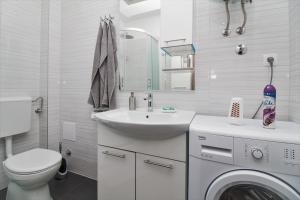 een badkamer met een wastafel en een wasmachine bij Apartment Split4me in Split