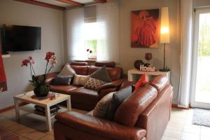 uma sala de estar com um sofá de couro e uma televisão em Ferienhaus Sternenhimmel em Thalfang