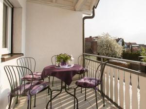balkon z 2 krzesłami i stołem z kwiatami w obiekcie Ruster Drachennest w mieście Rust
