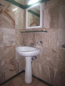 a bathroom with a white sink and a mirror at Villa Maraki in Agia Paraskevi
