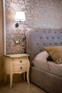 sypialnia z łóżkiem i stolikiem nocnym z lampką w obiekcie Palazzo Bove w mieście Galatone