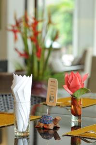 a table with a vase with a flower in it at Kasemsarn Hotel Chanthaburi in Chanthaburi