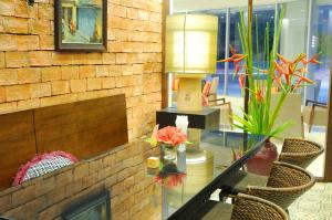 a glass table with a lamp and some chairs at Kasemsarn Hotel Chanthaburi in Chanthaburi
