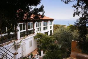 een wit huis met uitzicht op de oceaan bij Hotel Paola in Carloforte