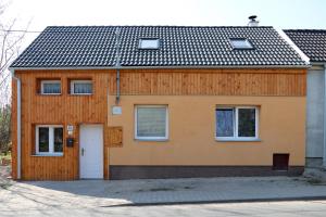 dom z drewnianą fasadą z białymi drzwiami w obiekcie Apartman Miky w mieście Dürnholz