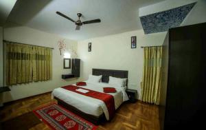 una camera da letto con un letto e un ventilatore a soffitto di Hotel Lemon Stay a Yercaud