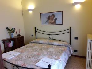 Un dormitorio con una cama y un cuadro en la pared. en Villa Capitolo, en Monopoli