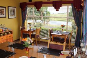 une salle à manger avec deux tables et une grande fenêtre dans l'établissement Waterfront Guest House, à Carolina