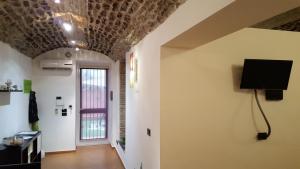 ミラッツォにあるInCentro Apartmentsの天井のある部屋(壁にテレビ付)