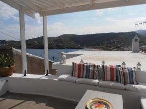 a porch with pillows and a view of the water at Hidesign Athens Traditional Stone House in Kea's Port in Korissia