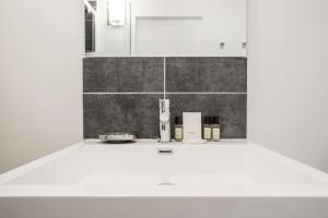 a white bathroom with a sink and a mirror at CMG Montorgueil IV in Paris