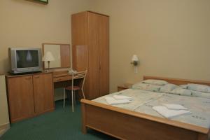 ジェールにあるKuckó Panzió Győrのベッドルーム(ベッド1台、デスク、テレビ付)