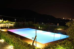 a large swimming pool lit up at night at La Castellana in Fosdinovo