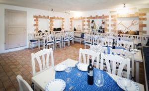 a dining room with white tables and white chairs at Weingut und Gästehaus Salzl in Illmitz