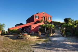 ein rotes Haus mit Treppen, die zu ihm führen in der Unterkunft Fundana Villas in Liapades