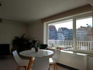 a room with a table and chairs and a large window at Appart Noah in Knokke-Heist