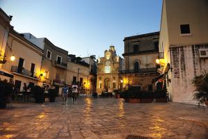 un gruppo di persone in piedi in un cortile con una torre dell'orologio di Casasimona a Oria