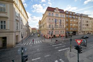 an empty street in a city with buildings at Hotel William in Prague