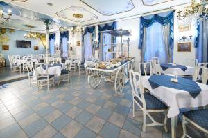 um restaurante com mesas e cadeiras azuis e brancas em Hotel William em Praga