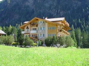 a large building in the middle of a field at Alpenhotel Panorama in Campitello di Fassa