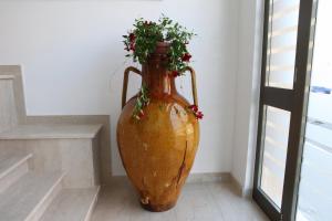 a large orange vase with a plant in it at B&B Al Picchio in Monopoli