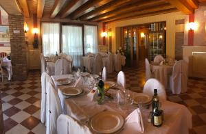 a dining room with white tables and white chairs at Hotel La Campagnola 1926 in Zevio