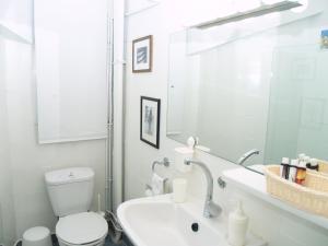 Un baño blanco con inodoro y lavabo. en Artistic Deco Apartment, en Atenas 22 fotos más