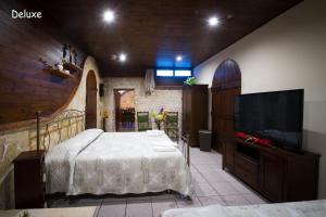 een slaapkamer met een bed en een flatscreen-tv bij La Cutizza B&B in Martina Franca