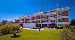 a large building with flags on top of it at Garden Hotel in Latina