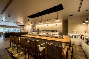 a restaurant with a long bar and chairs at Hotel Resol Nagoya in Nagoya