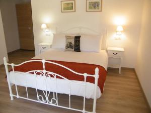 a bedroom with a white bed and two night stands at Clos Vieux Rochers Vineyard in Puisseguin