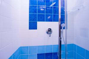 a bathroom with a blue shower curtain and a blue wall at La Valle Delle Ferriere in Amalfi