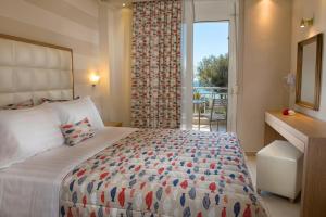 a bedroom with a large bed and a large window at Georgalas Sun Beach Resort in Nea Kalikratia