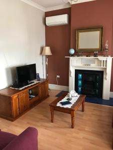 a living room with a fireplace and a coffee table at Jadan Cottages in Broken Hill