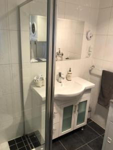 a white bathroom with a sink and a shower at Jadan Cottages in Broken Hill