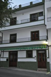 a white and green building with a balcony at Casa Tamayo in Órgiva