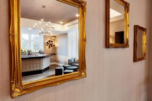 a living room with a mirror and a painting on the wall at Oddfellows On The Park in Cheadle