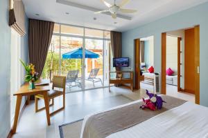 ein Schlafzimmer mit Bett und ein Wohnzimmer in der Unterkunft Apsara Beachfront Resort & Villa - SHA Extra Plus in Khao Lak