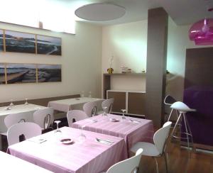 a restaurant with two tables and white chairs and pink tablecloths at Isla Nova Hotel in Foz