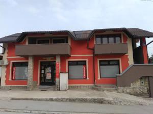 a red building with windows and a red at Rooms Hazler in Slunj