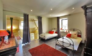 ル・ヴィガンにあるLes Jardins d'Ungaro / Manoir La Barrièreのベッドルーム1室(ベッド2台付)、暖炉付きのベッドルーム1室が備わります。