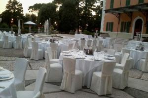 a group of tables and chairs with white tables and white chairs at Hotel Villa Verdefiore in Appignano