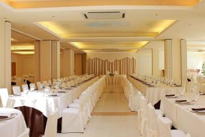 a large banquet hall with white tables and white chairs at Hotel Villa Verdefiore in Appignano