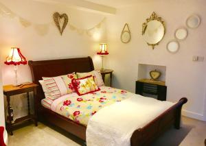 una camera con un letto e due lampade e specchi di Dugdales Cottage a Settle