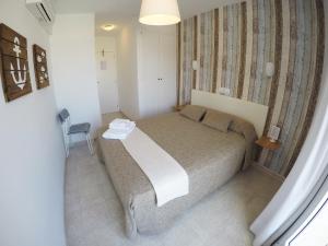1 dormitorio pequeño con 1 cama y 1 silla en Hostal del Mar, en Tossa de Mar