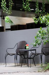 two chairs and a table with a vase of flowers on it at Kasemsarn Hotel Chanthaburi in Chanthaburi