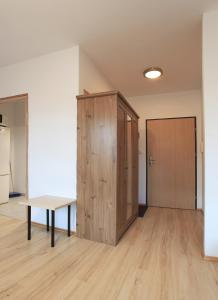 pusty pokój ze stołem i drewnianą szafką w obiekcie Kawalerka cynamonowa w Gdańsku