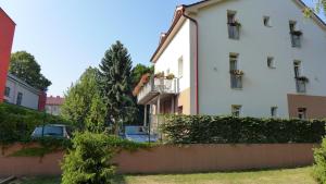 a white building with cars parked in front of it at Penzion Park - 2 izbové apartmány in Nové Mesto nad Váhom