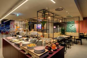 a buffet line with food on it in a restaurant at MEININGER Hotel Leipzig Hauptbahnhof in Leipzig